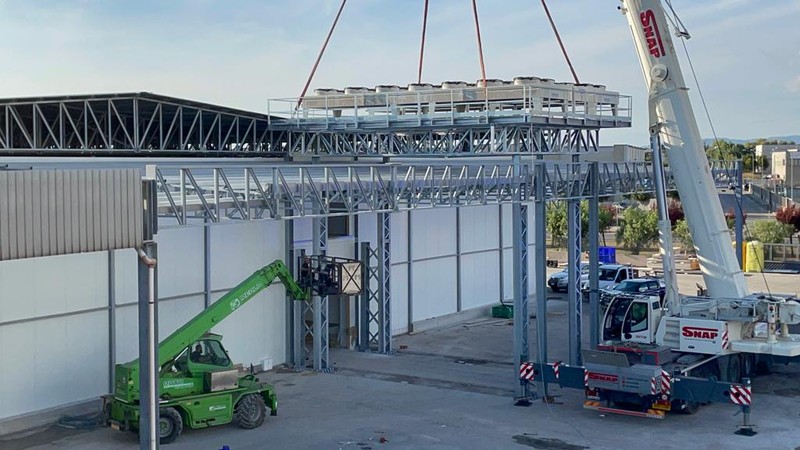 Gru che solleva un’unità con ventilatori sulla struttura in acciaio di un impianto